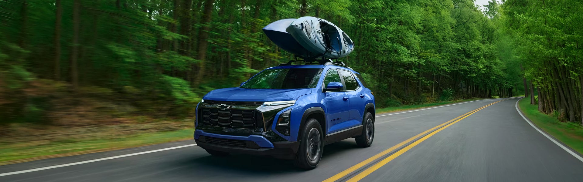 Blue Chevy equinox with a kayak on the roof.
